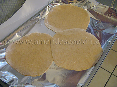 A pan covered in foil with three uncooked low fat homemade tortillas resting on top.