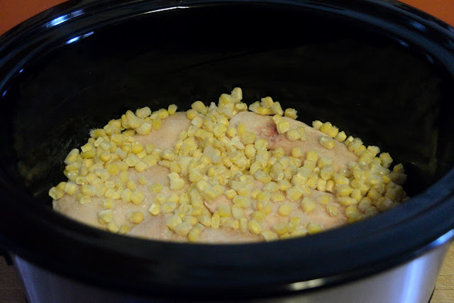 Frozen corn being added to the crock pot.