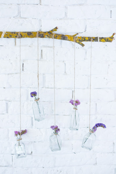 Rama con botellas de cristal y flores