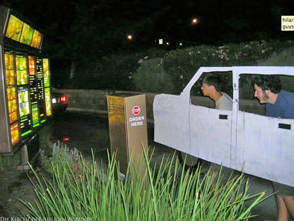 Lustige junge Männer mit selbstgebautem Auto in Drive Inn Restaurant