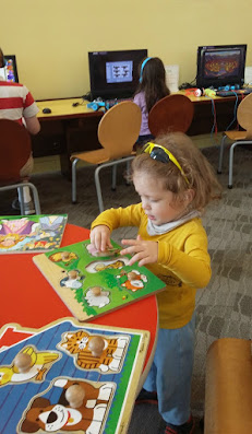 Toddler Tyler playing with puzzles at the library