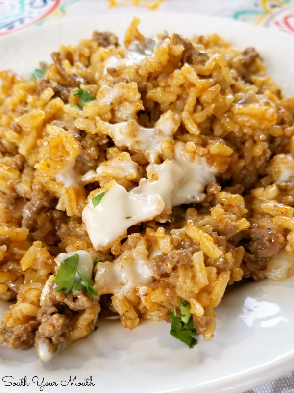 Taco Rice Skillet Dinner with Queso! A one-pan recipe made with ground beef, taco seasoning and Mexican style rice drenched in an easy queso cheese sauce.