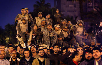 Anti-government protesters and Army soldiers watch and listen to the statement of Egyptian Presiden