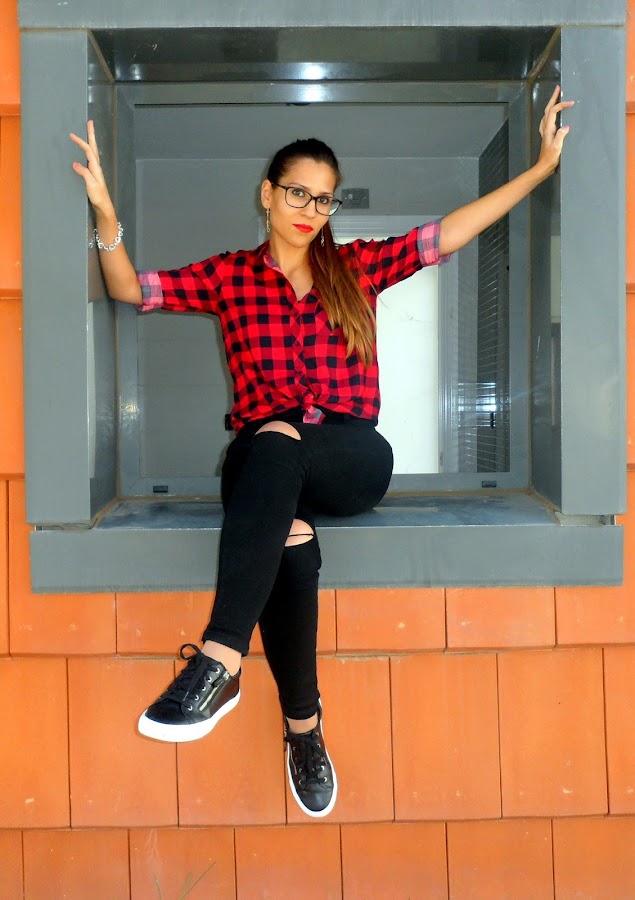 Camisa de cuadros con chaqueta de cuero, jeans rotos y bambas