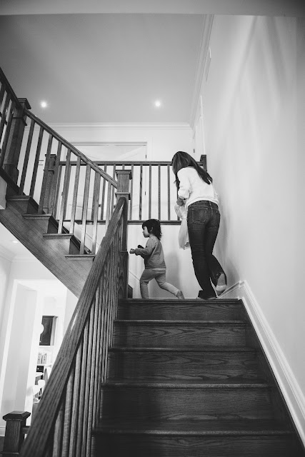 Mom and daughter going upstairs to get ready for toddler birthday party during lifestyle photo session in Ottawa Barrhaven 