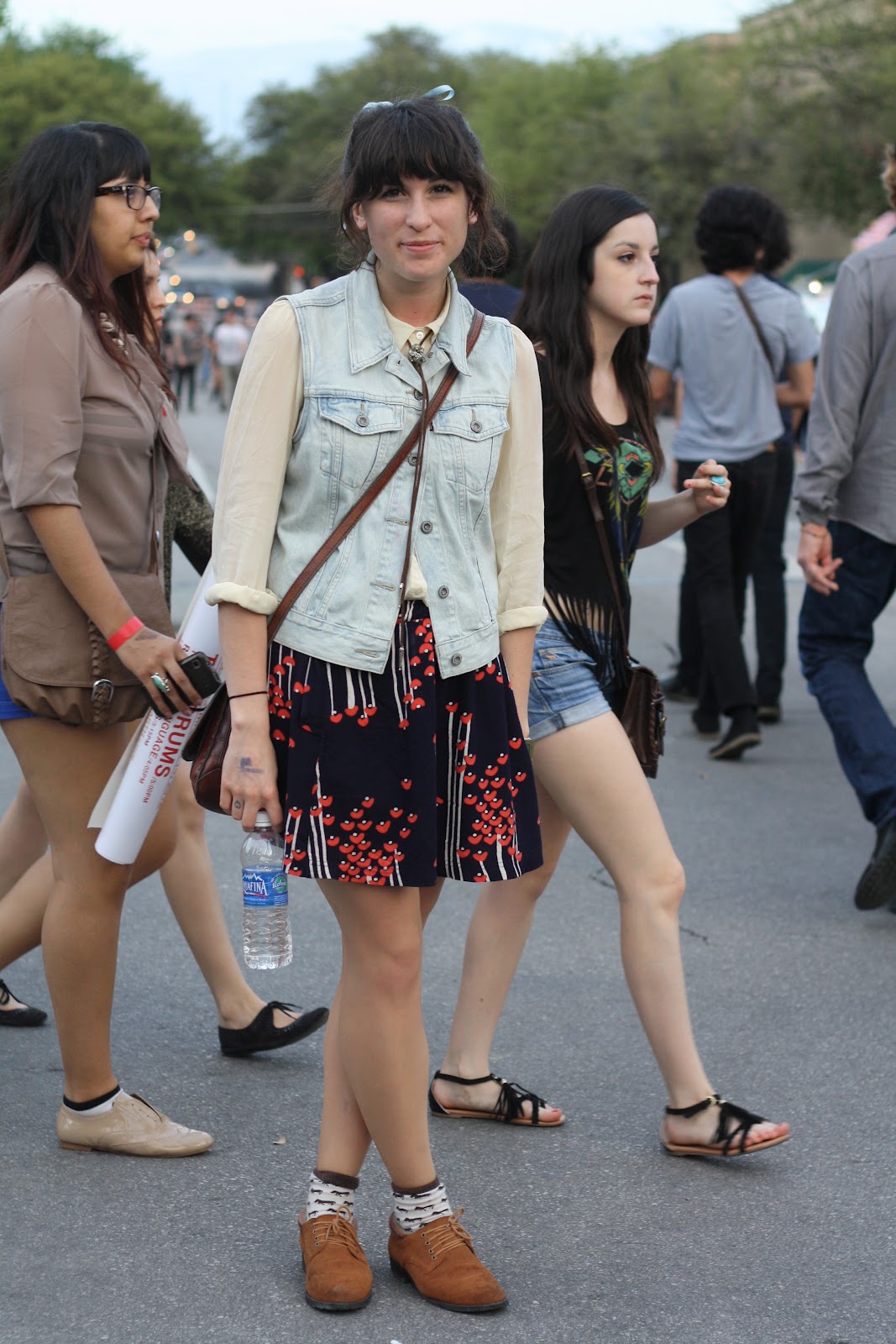 girl wearing a white shirt, denim vest, and printed skirt at sxsw