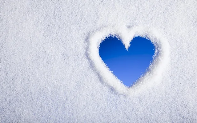 Witte winter achtergrond met een liefdes hartje in de sneeuw