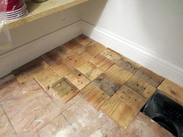 laying out pallet wood on pantry floor over underlayment