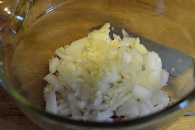 Minced garlic, and diced onions in a mixing bowl. 