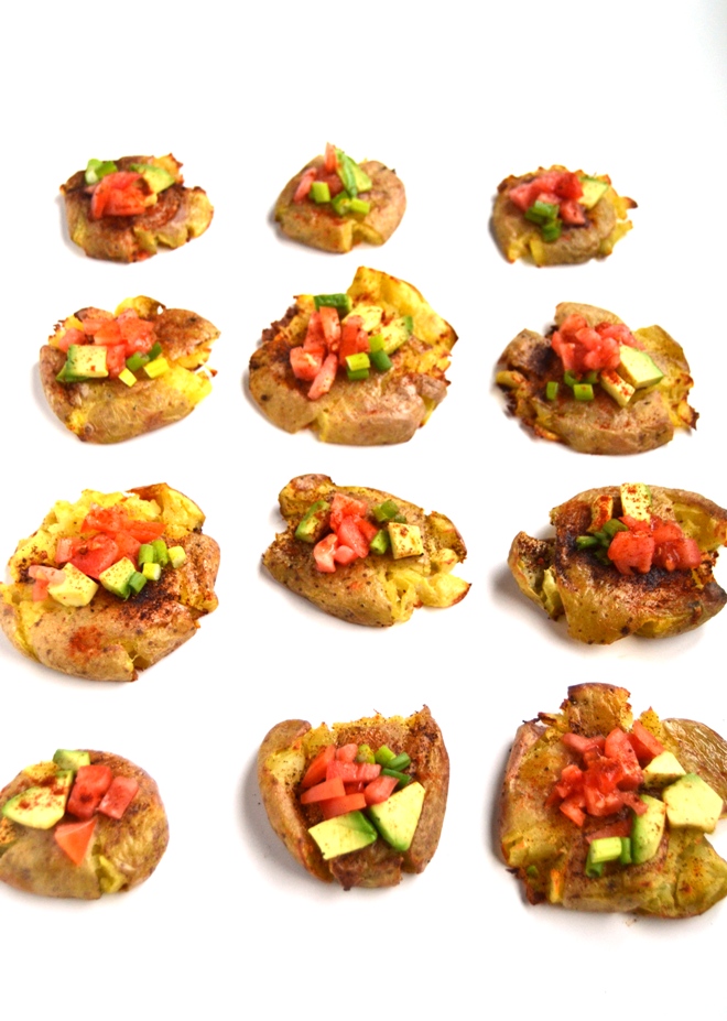 Spicy Smashed Potatoes are crisp on the outside, soft on the inside and loaded with spicy flavors and topped with avocado, tomato and green onion for the perfect side dish or appetizer. www.nutritionistreviews.com