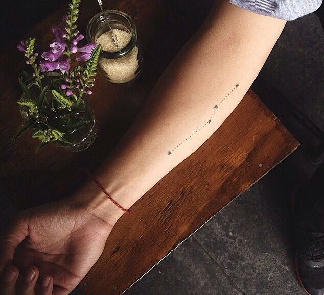 chica con tatuaje de constelacion en el antebrazo