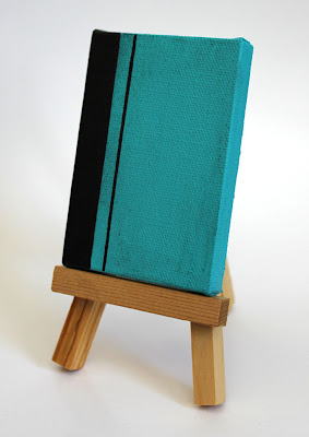 turquoise and black color field painting on an easel