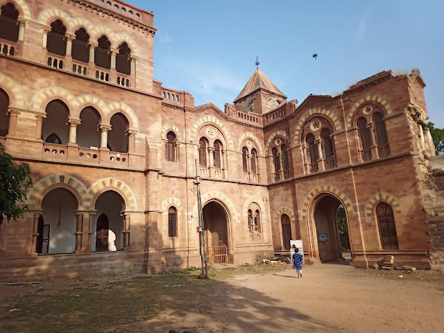 Stone exterior of Prag Mahal Palace with arched doorways and windows in Bhuj
