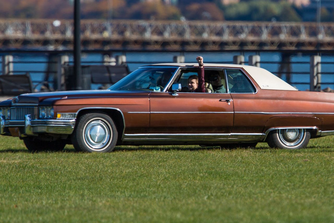 Chloezinha encarando um carro antigo