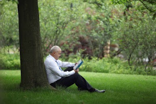 businessman reading under a tree