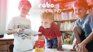 Children playing with iPad and robot
