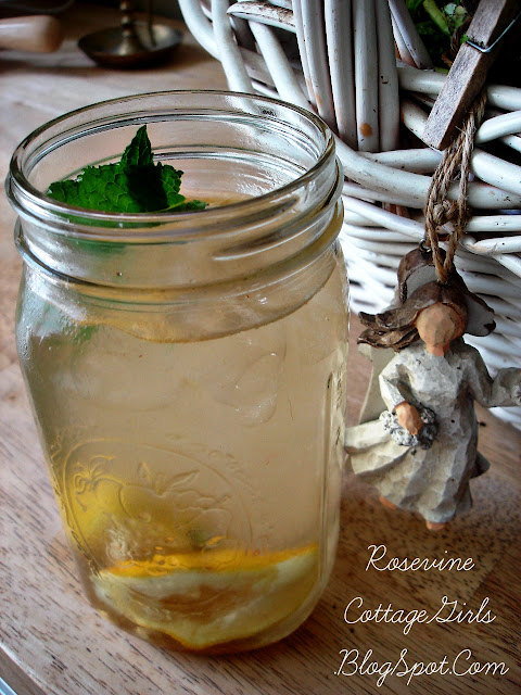canning jar filled with cold delicious lemonade and slices of lemon in the glass sitting on  wooden table - recipe for lemonade rose vine cottage girls dot com