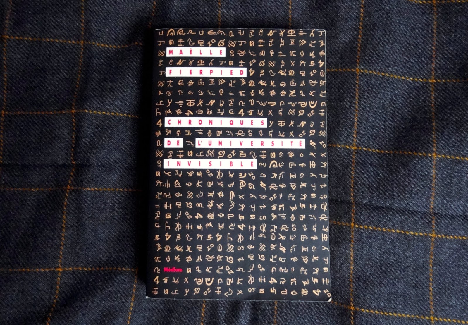 livre dont la couverture est noire et décorée d'idéogrammes inconnus