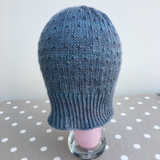 Hand-knit hat blocking on a balloon