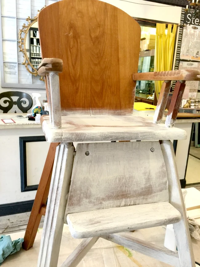 Partially painted wooden highchair