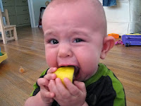 Bir ayva veya limon yerken yüzünü ekşiten çocuk