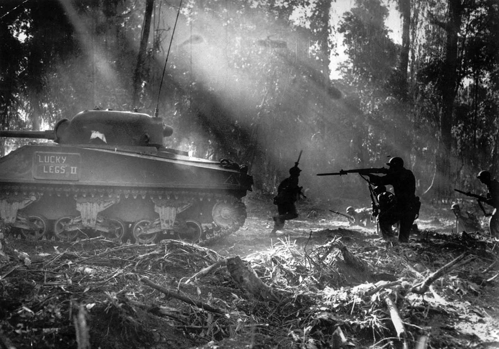 Following in the cover of a tank, American infantrymen secure an area on Bougainville, Solomon Islands, in March 1944, after Japanese forces infiltrated their lines during the night.