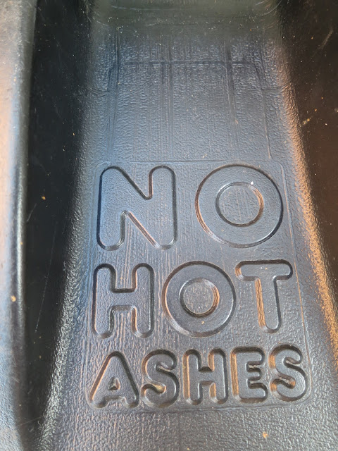 Black plastic dustbin lid with words 'NO HOT ASHES'