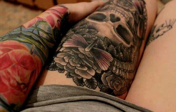 chica con tatuaje de calavera y mariposa en la pierna
