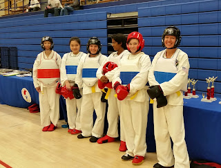 Martial arts women in sparring pads Martial arts women in sparring pads getting ready to spar at a Taekwondo tournament