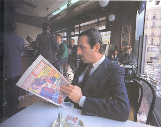 Home llegint el diari al bar