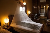 Bir yatak odası yatağı üzerine gerilmiş cibinlik tülü