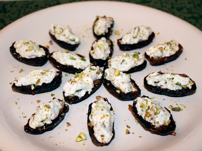 Top of dates stuffed with cardamom goat cheese and salted pistachios.