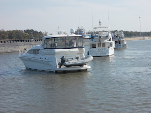 Four boats lined up at the lock, waiting for the towboat to pass.