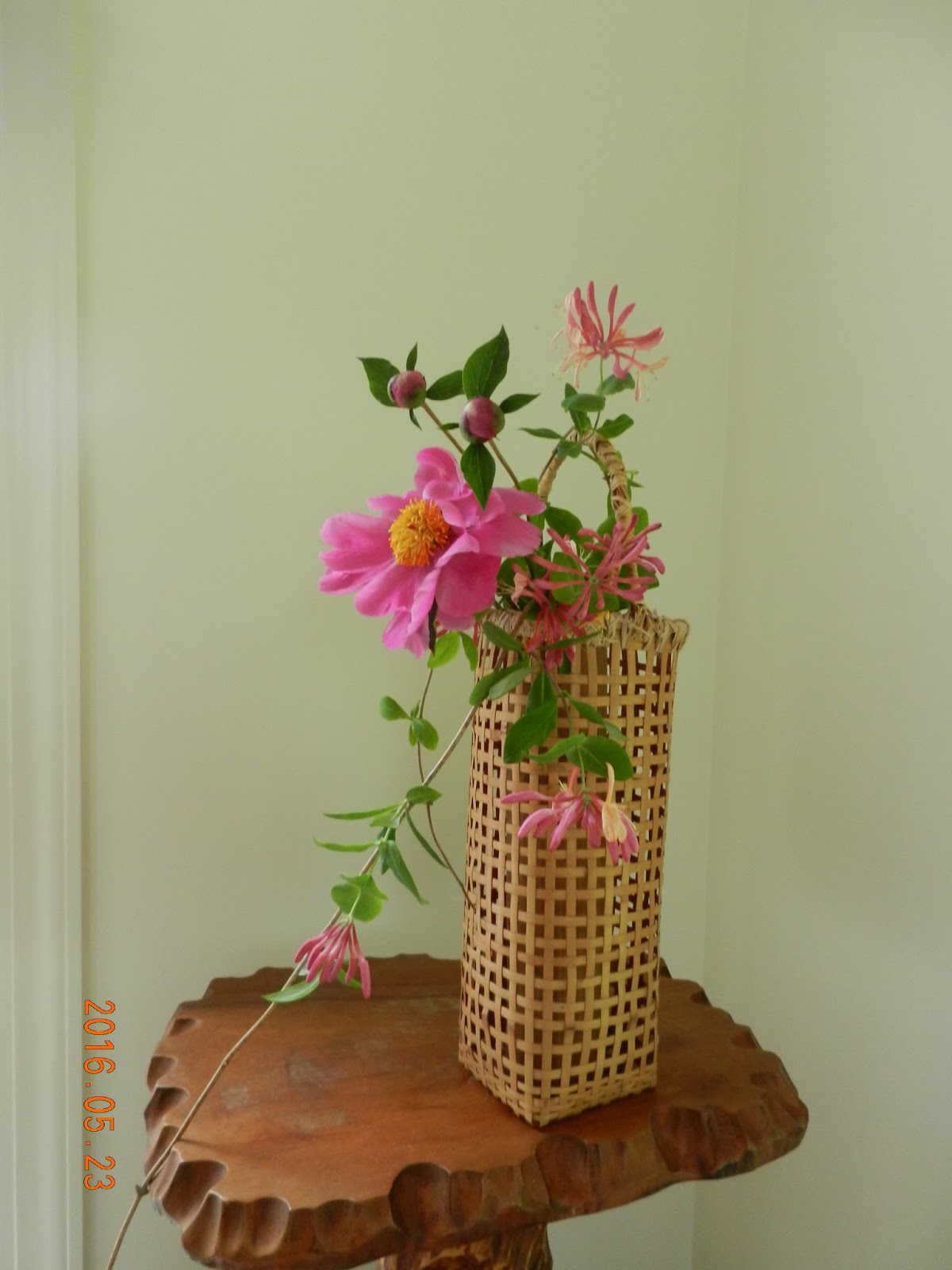 Orchids and Ikebana Arrangement in a basket with peony.