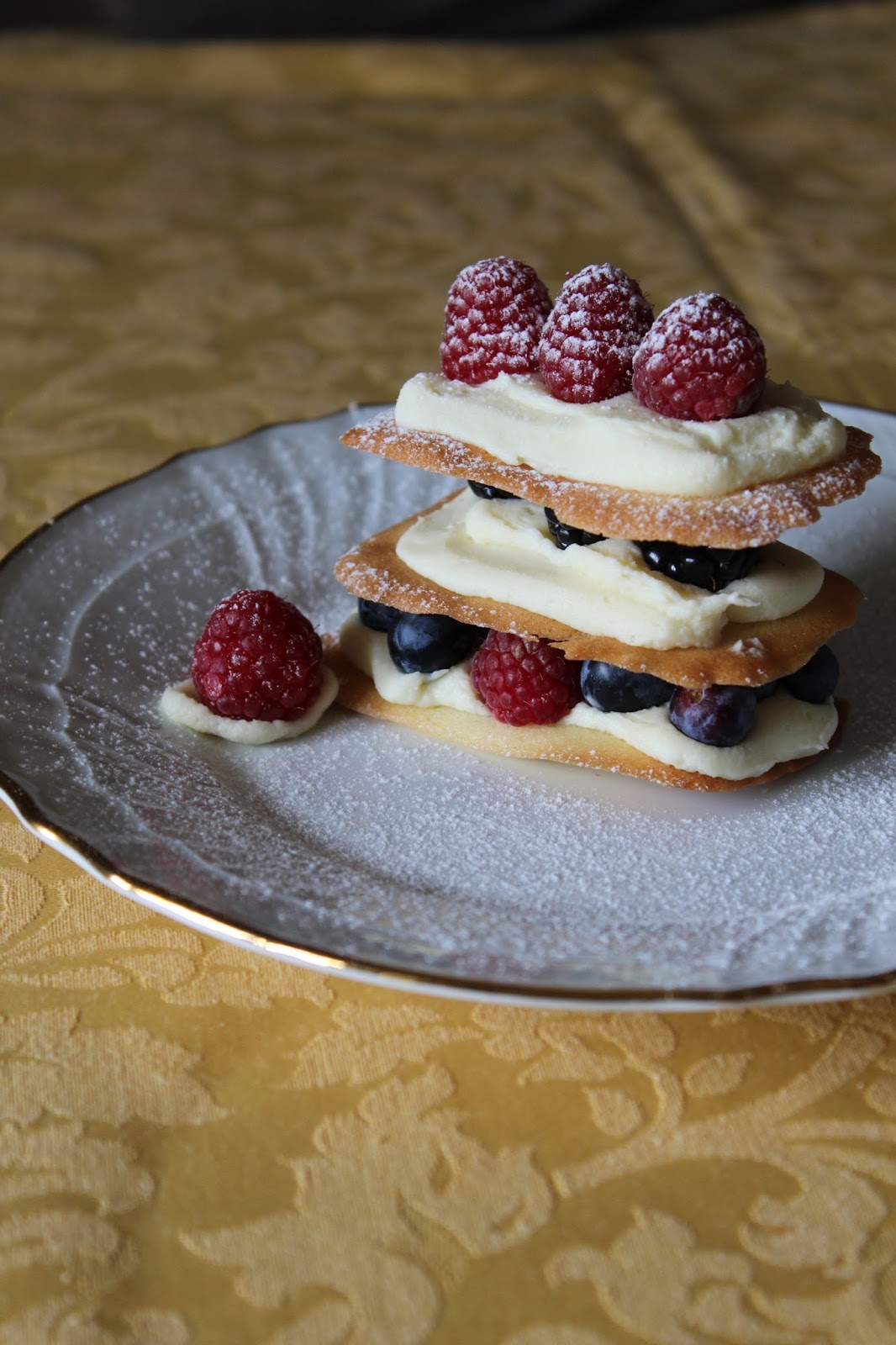 millefoglie di cialde croccanti con ganache al cioccolato bianco e frutti di bosco.