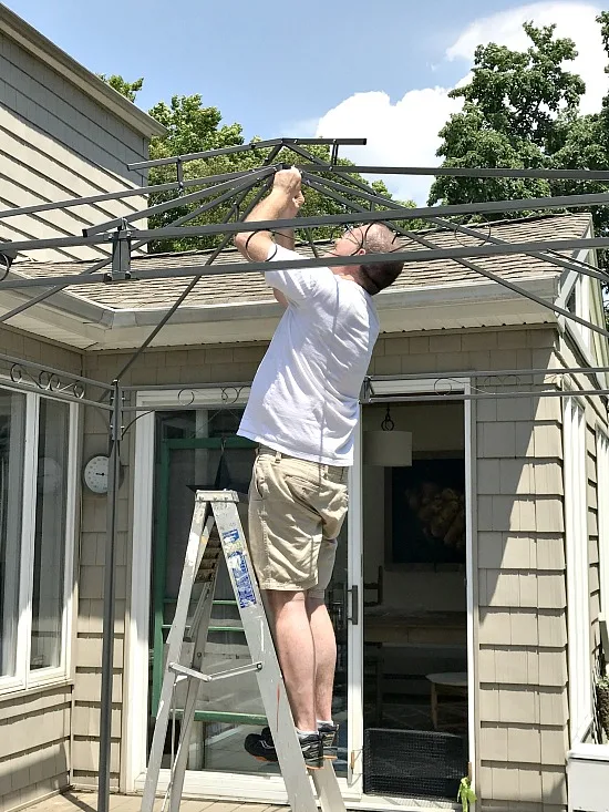 Man on ladder gazebo assembly