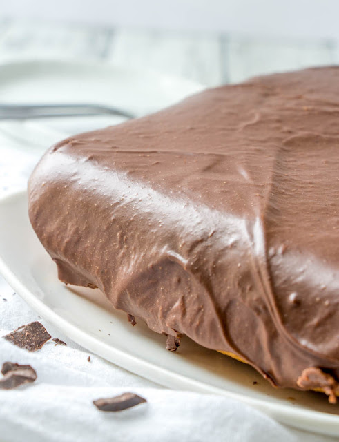 Sometimes you just need a little something sweet. This simple cake is creamy and delicious and the frosting is fudgy and delicious. This Farmer's Daughter Cake is a must make treat! Close up of fudgy frosting on square farmer's daughter cake