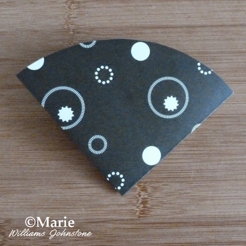 Twice folded circle of paper with black and white patterns