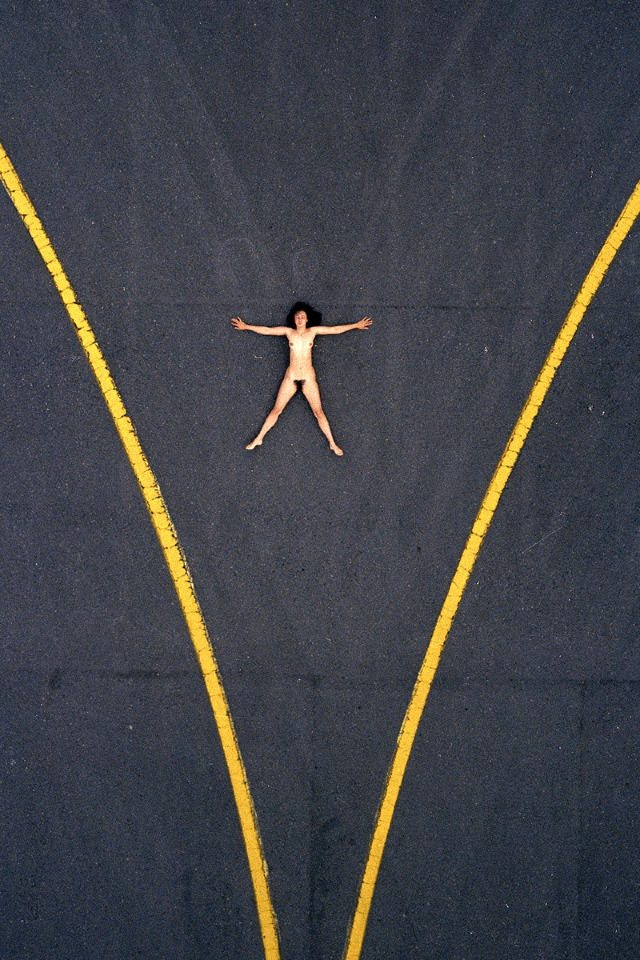 vista aerea de mujer desnuda en asfalto