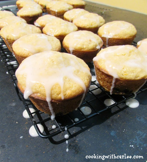 These muffins scream summertime. They are loaded with yellow squash, lemon and blueberry for a bright and fruity taste. The optional glaze makes them extra sweet and delicious! glaze dripping off warm muffins on cooling tray