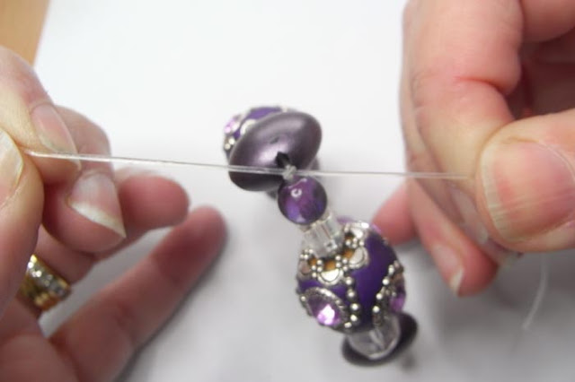 Pulling the double knot in the beading elastic tightly