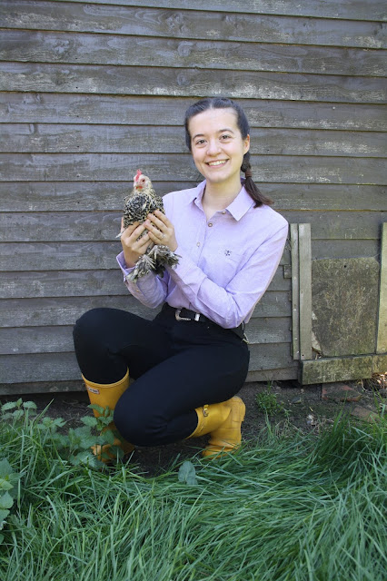 Abbey wearing a lilac shirt holds a Bantam chicken