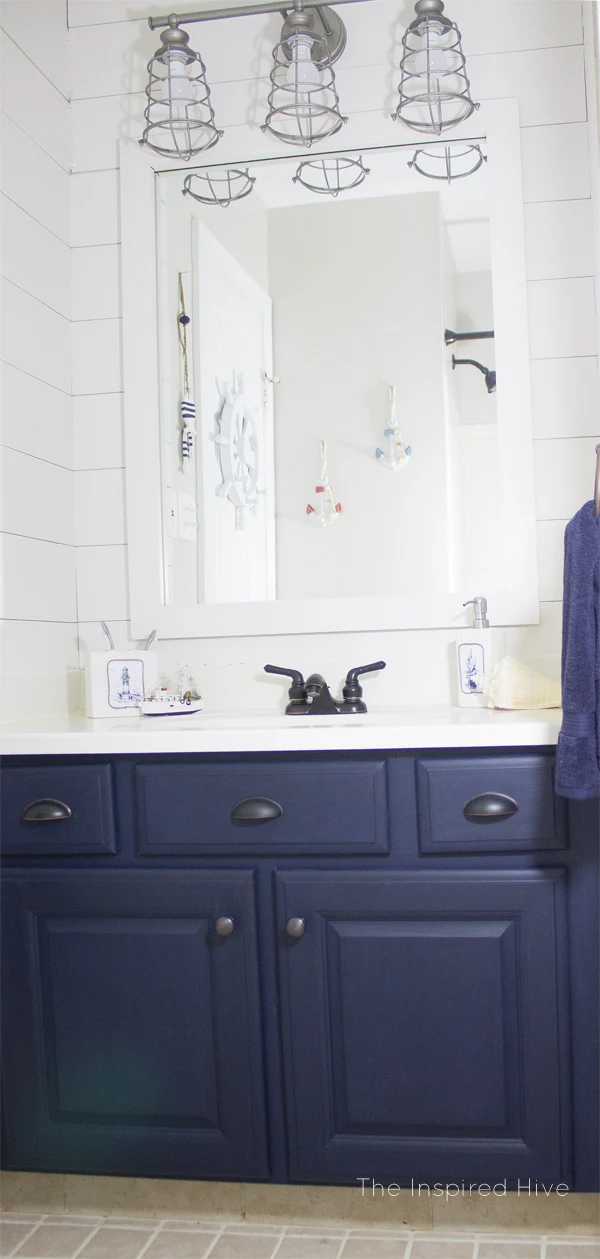 Nautical bathroom makeover with navy blue cabinets