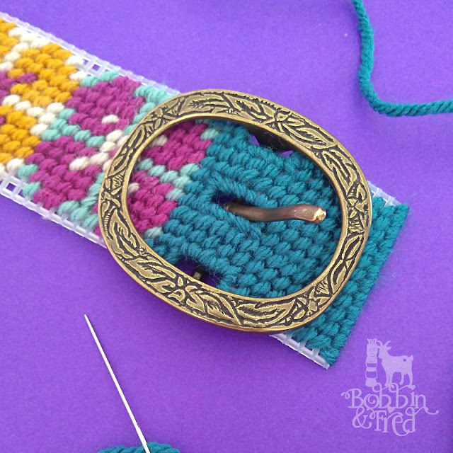 Decorative Bronze Belt Buckle being set into a needlepoint belt by Bobbin and Fred