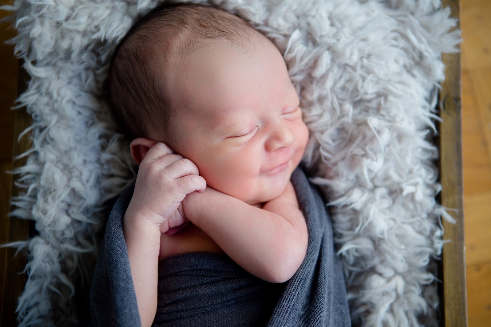 newborn baby boy swaddled with smile
