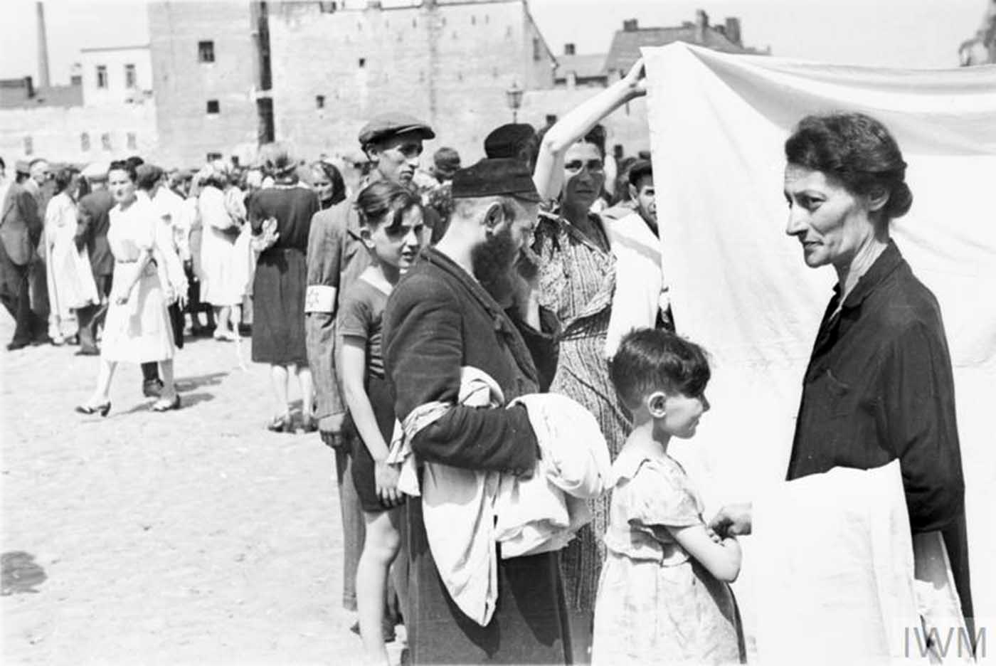 Ghetto residents buying and selling bedsheets in a street market.