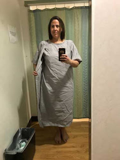 Me standing in an MRI dressing room wearing a long patient gown