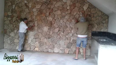 Bizzarri fazendo o revestimento de pedra, com pedra moledo, sendo o revestimento com pedra na parede da adega da residência em Itatiba-SP com essa pedra moledo na cor bege com espessura de 15 a 20 cm.