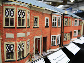 Row of miniature terrace houses with paper tape on the windows.