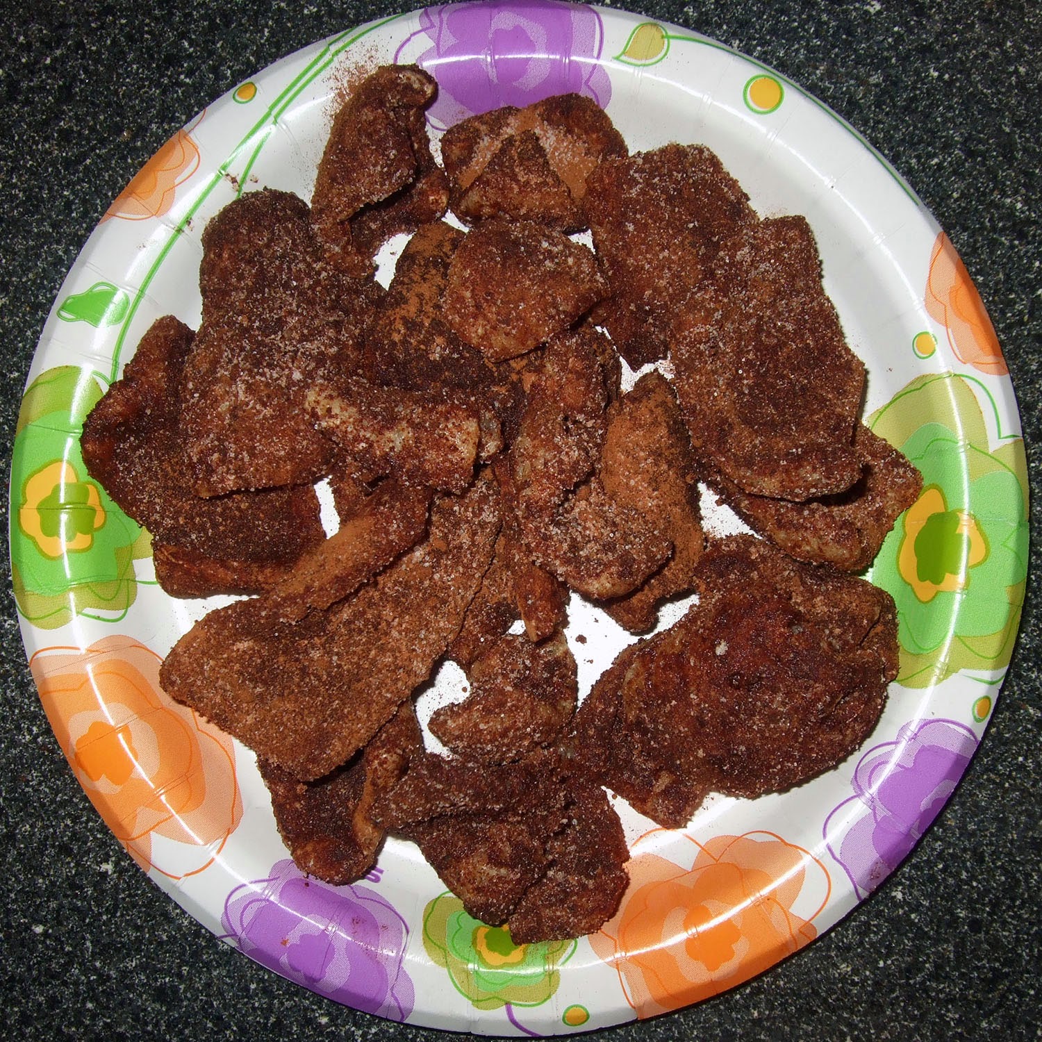 Cinnamon-sweetener coated pork rinds on a plate.